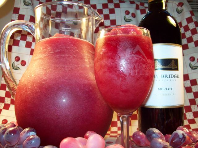 picture of a pitcher and glass of Vino Slush Wine Slushies and a bottle of wine